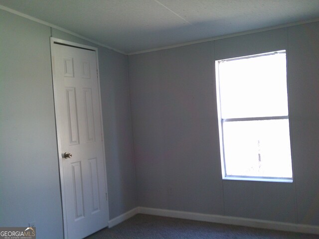 unfurnished living room with ceiling fan and dark carpet