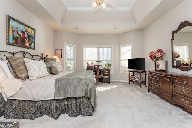 carpeted bedroom with an inviting chandelier, ornamental molding, and a raised ceiling