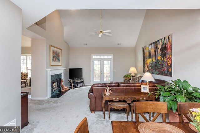 carpeted living room featuring a high end fireplace, a wealth of natural light, french doors, and ceiling fan