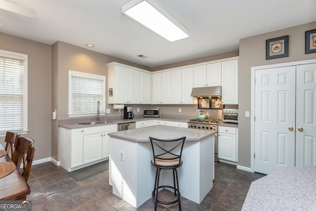 kitchen featuring white cabinetry, appliances with stainless steel finishes, a center island, and sink