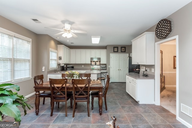 dining space featuring ceiling fan and sink