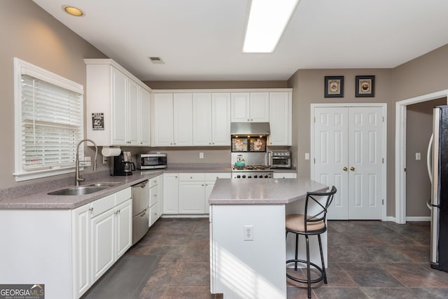 kitchen featuring sink, a breakfast bar area, appliances with stainless steel finishes, a center island, and white cabinets