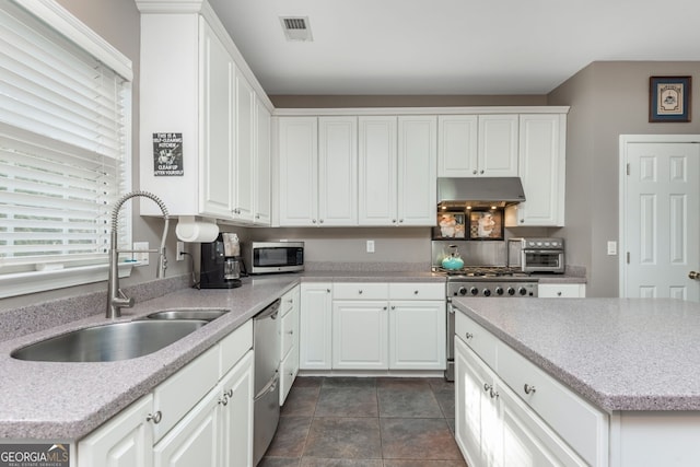 kitchen featuring white cabinetry, sink, light stone counters, and appliances with stainless steel finishes