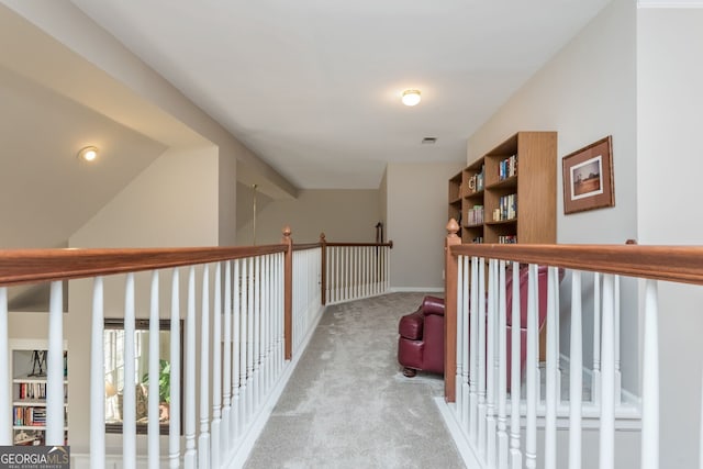 hall with vaulted ceiling and light colored carpet