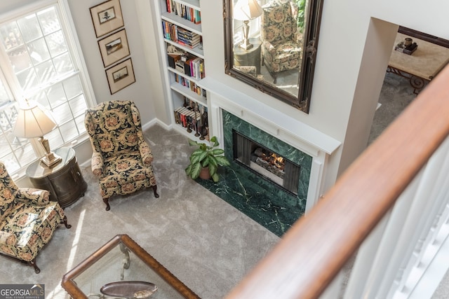 carpeted living room featuring a premium fireplace and built in features