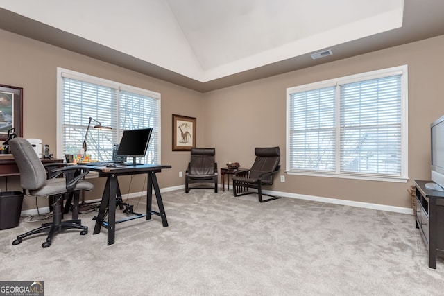 carpeted home office featuring a raised ceiling and high vaulted ceiling