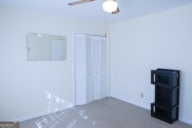 unfurnished bedroom featuring ceiling fan, a closet, and carpet flooring