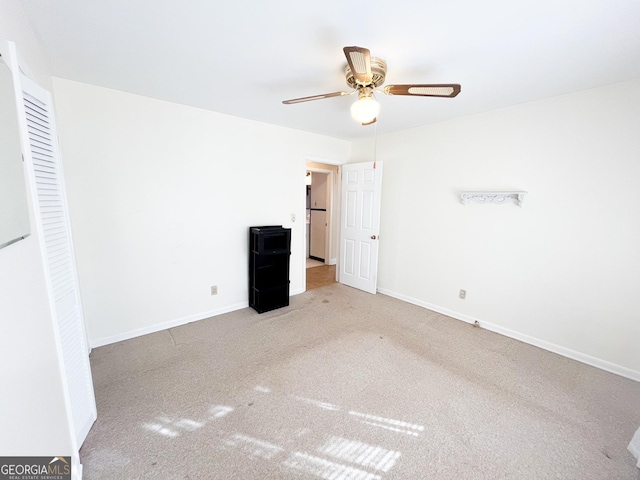 unfurnished bedroom with ceiling fan and light colored carpet