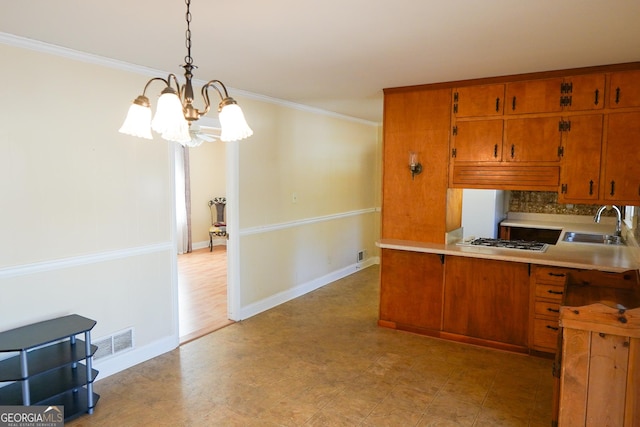 kitchen featuring decorative light fixtures, a notable chandelier, sink, and crown molding