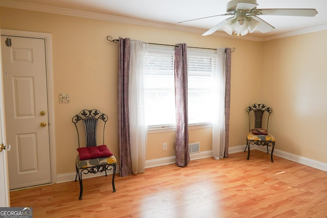 living area featuring ceiling fan, ornamental molding, and light hardwood / wood-style flooring