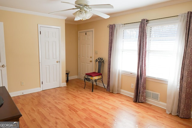 interior space featuring light wood-type flooring, ornamental molding, and a healthy amount of sunlight