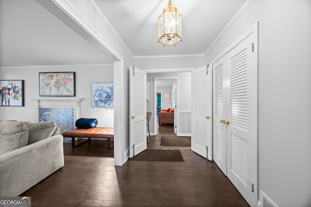 hall featuring dark wood-style floors, a chandelier, and crown molding