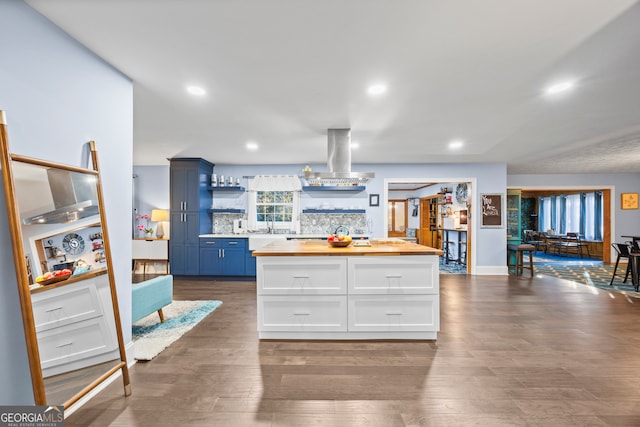 kitchen with butcher block countertops, white cabinetry, a center island, open shelves, and island exhaust hood