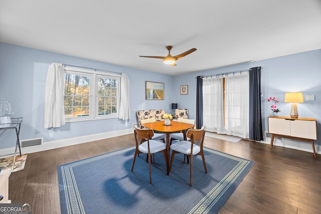 dining area with dark wood-style floors, visible vents, and baseboards