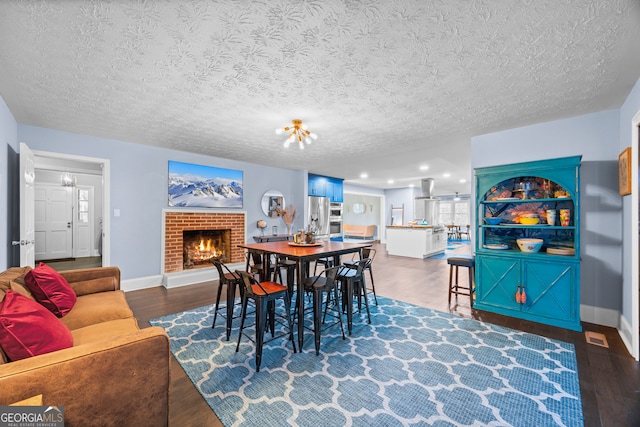 dining room with a fireplace, baseboards, dark wood finished floors, and a textured ceiling