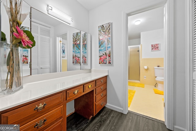 full bath featuring toilet, wood finished floors, vanity, a shower stall, and a closet