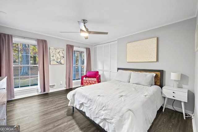 bedroom featuring multiple windows, ornamental molding, and dark wood finished floors