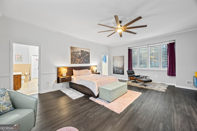 bedroom with dark wood-style flooring, crown molding, a ceiling fan, connected bathroom, and baseboards