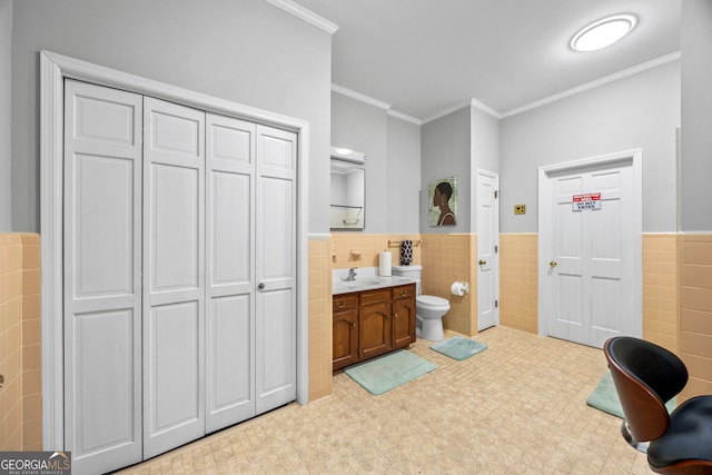 bathroom featuring toilet, ornamental molding, a closet, and vanity