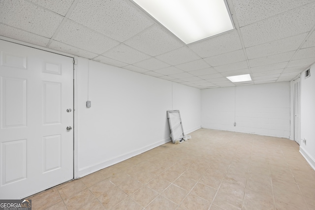 finished basement with a paneled ceiling and baseboards