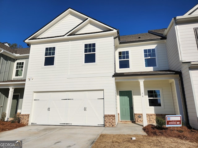 view of front of home with a garage, concrete driveway, and brick siding