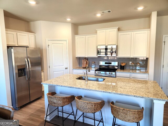 28 Russet Way Lot 60, Newnan, GA 30263 - kitchen with appliances with stainless steel finishes, wood finished floors, white cabinetry, a sink, and recessed lighting