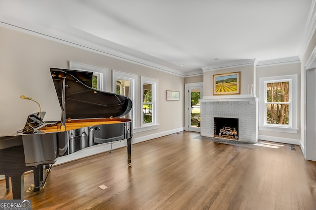 interior space with a brick fireplace, hardwood / wood-style floors, and ornamental molding