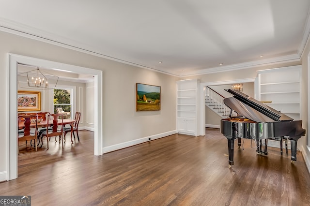 miscellaneous room with built in shelves, a notable chandelier, ornamental molding, and dark hardwood / wood-style floors