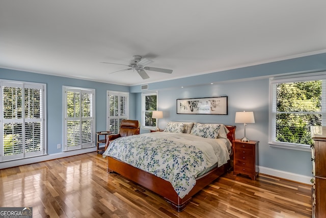 bedroom featuring ceiling fan, crown molding, and hardwood / wood-style floors