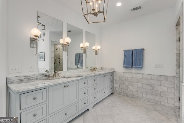 bathroom featuring an enclosed shower, vanity, and a notable chandelier