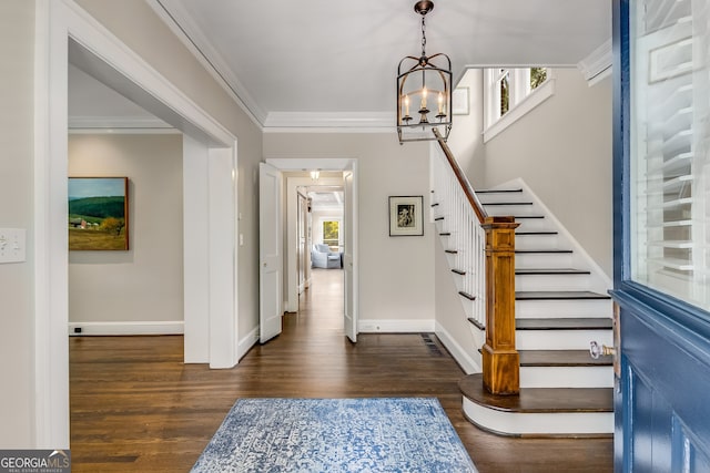 entrance foyer featuring an inviting chandelier, crown molding, and dark hardwood / wood-style floors