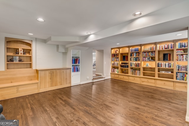 workout room featuring built in shelves and hardwood / wood-style floors