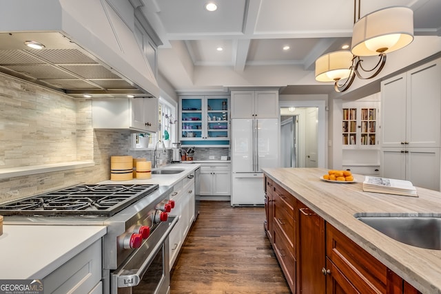 kitchen featuring premium appliances, custom range hood, tasteful backsplash, sink, and beam ceiling