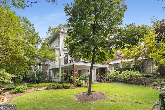 view of front of property with a front lawn, a balcony, and covered porch