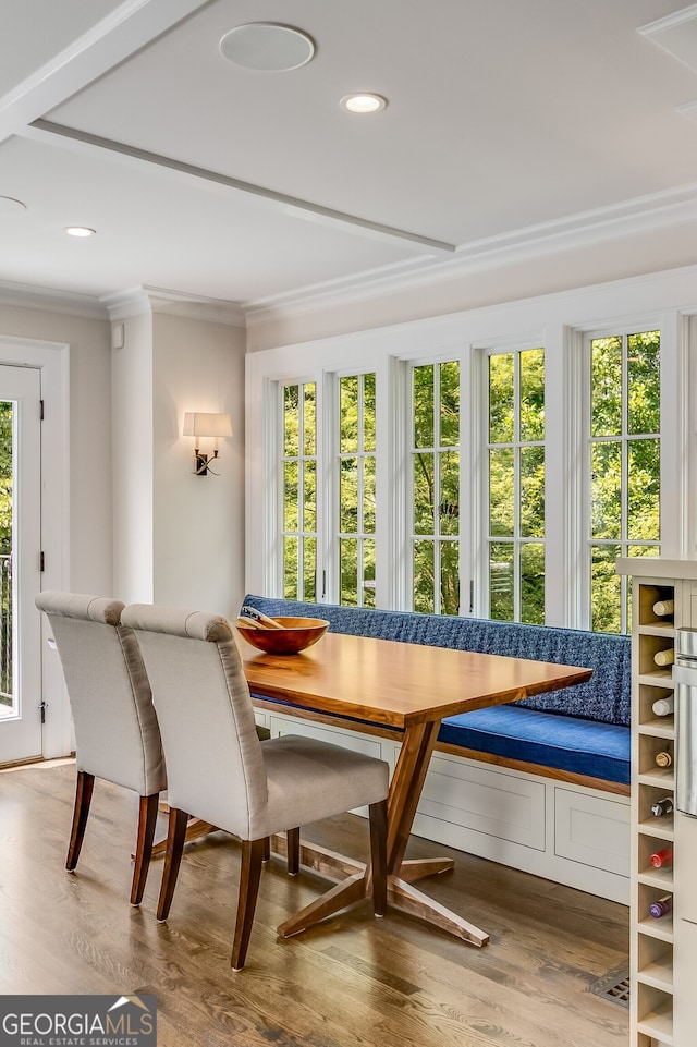 dining area featuring hardwood / wood-style flooring, breakfast area, and crown molding