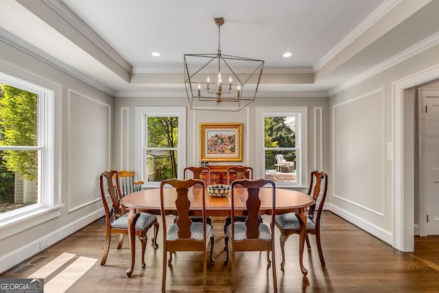 dining space featuring an inviting chandelier, a tray ceiling, and ornamental molding