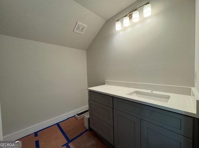 bathroom featuring vanity and lofted ceiling