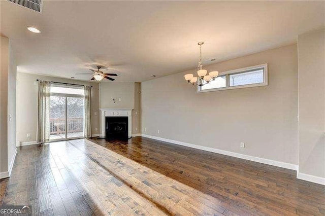 unfurnished living room with dark hardwood / wood-style flooring and ceiling fan with notable chandelier