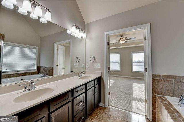 bathroom featuring lofted ceiling, vanity, ceiling fan, and a relaxing tiled tub