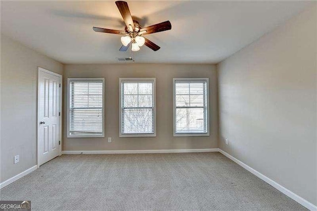 empty room featuring ceiling fan and light colored carpet