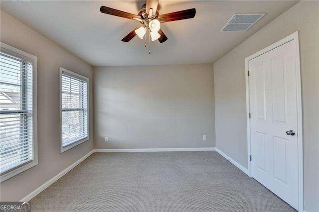 carpeted spare room with ceiling fan