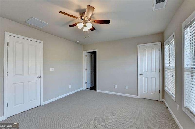 unfurnished bedroom featuring light carpet and ceiling fan