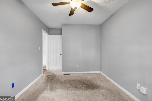 empty room with light carpet, a textured ceiling, and ceiling fan