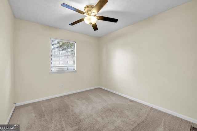 carpeted spare room featuring ceiling fan and a textured ceiling