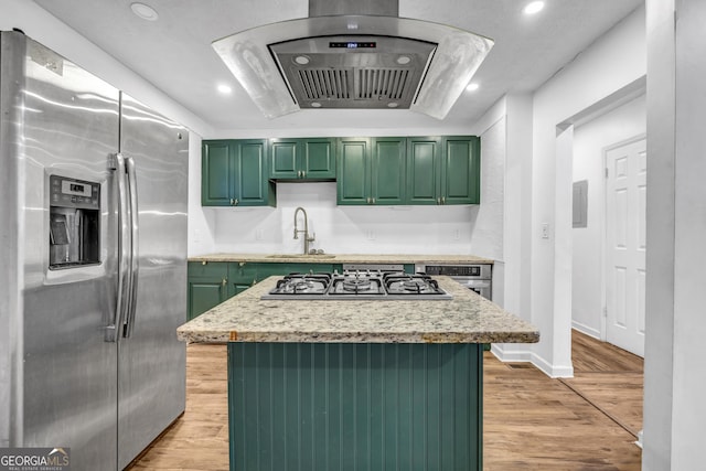 kitchen featuring sink, exhaust hood, green cabinets, stainless steel appliances, and light wood-type flooring