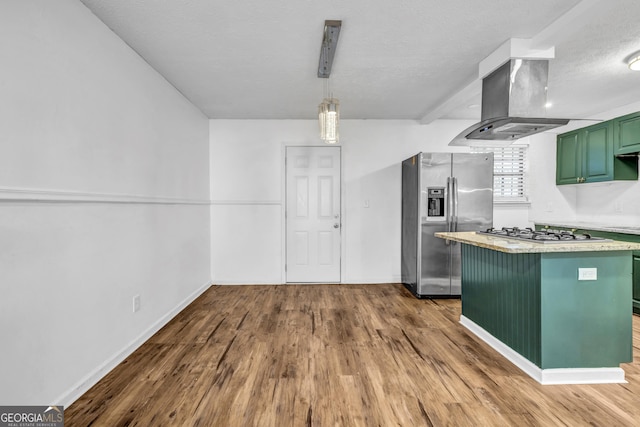 kitchen featuring wood-type flooring, appliances with stainless steel finishes, green cabinets, pendant lighting, and island exhaust hood