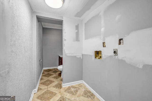 laundry room featuring washer hookup and a textured ceiling