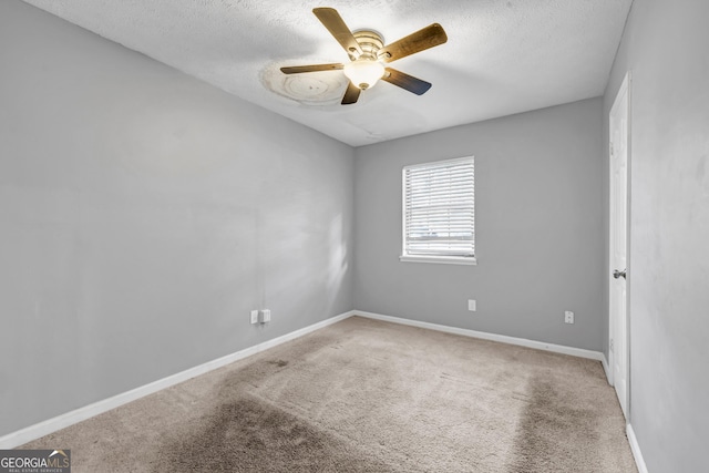 unfurnished room with ceiling fan, light carpet, and a textured ceiling