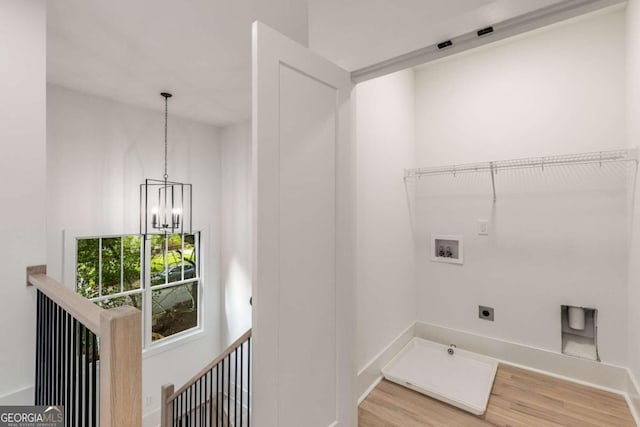 clothes washing area featuring washer hookup, a notable chandelier, hookup for an electric dryer, and hardwood / wood-style floors