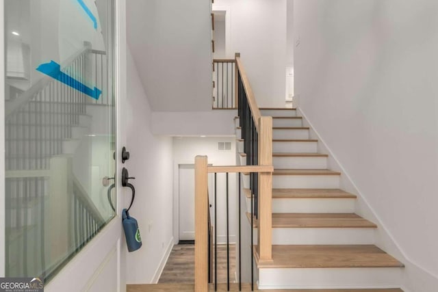 staircase with hardwood / wood-style flooring